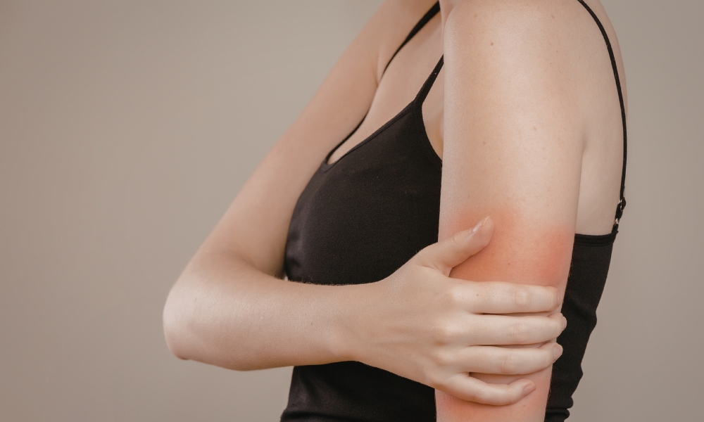 Person experiencing left arm pain that may be associated with heart attack warning signs
