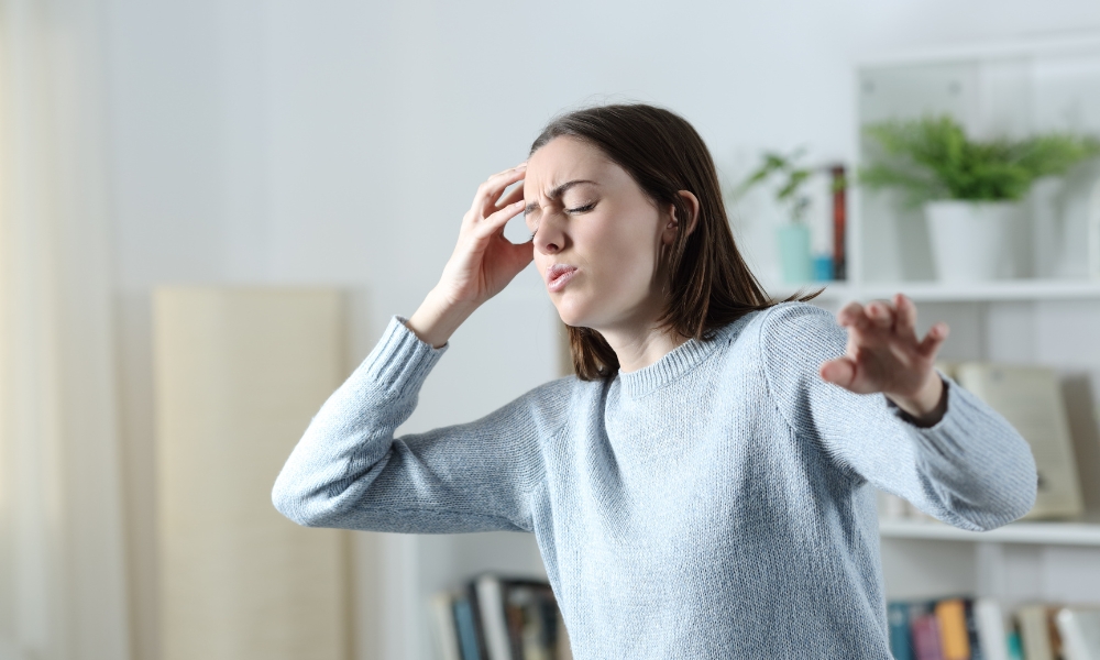 Woman experiencing sudden dizziness and loss of balance at home