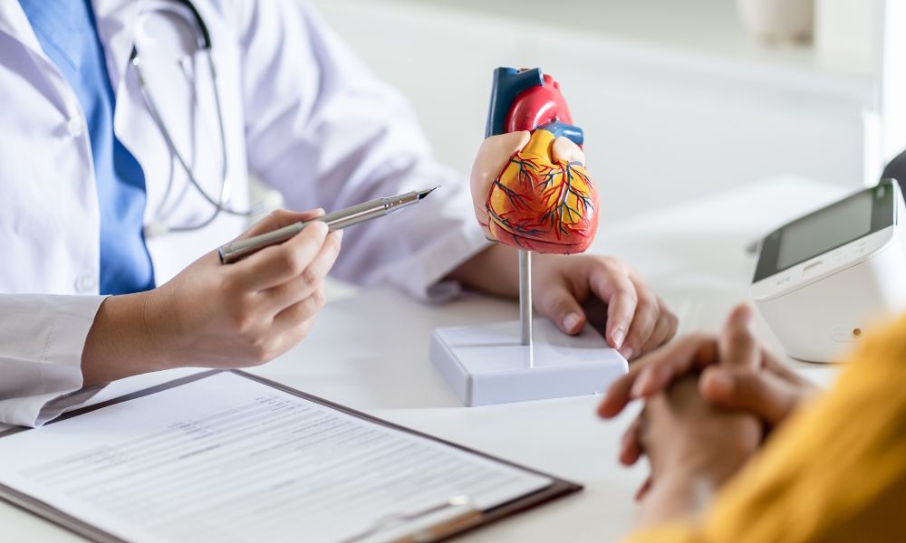 Emergency room doctor reviewing EKG monitor for heart rhythm and palpitations evaluation